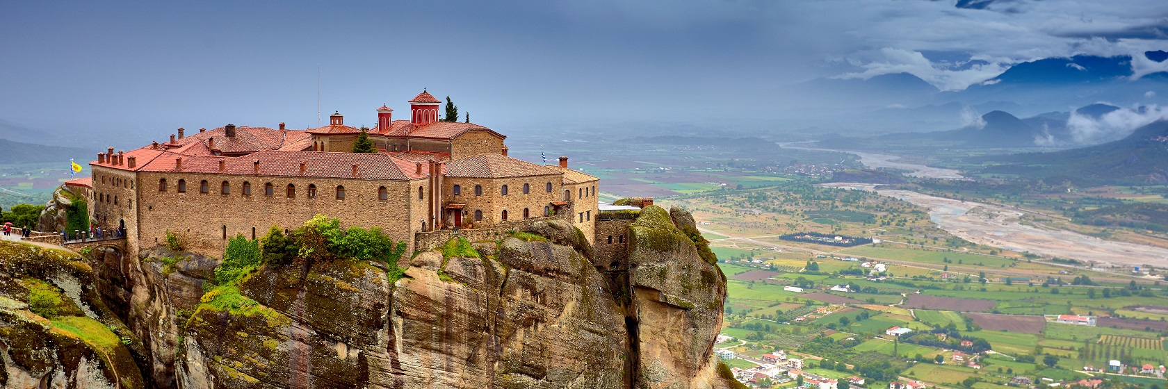 Ett kloster p� toppen av en bergsformation med lodr�ta klippv�ggar vid Meteora.