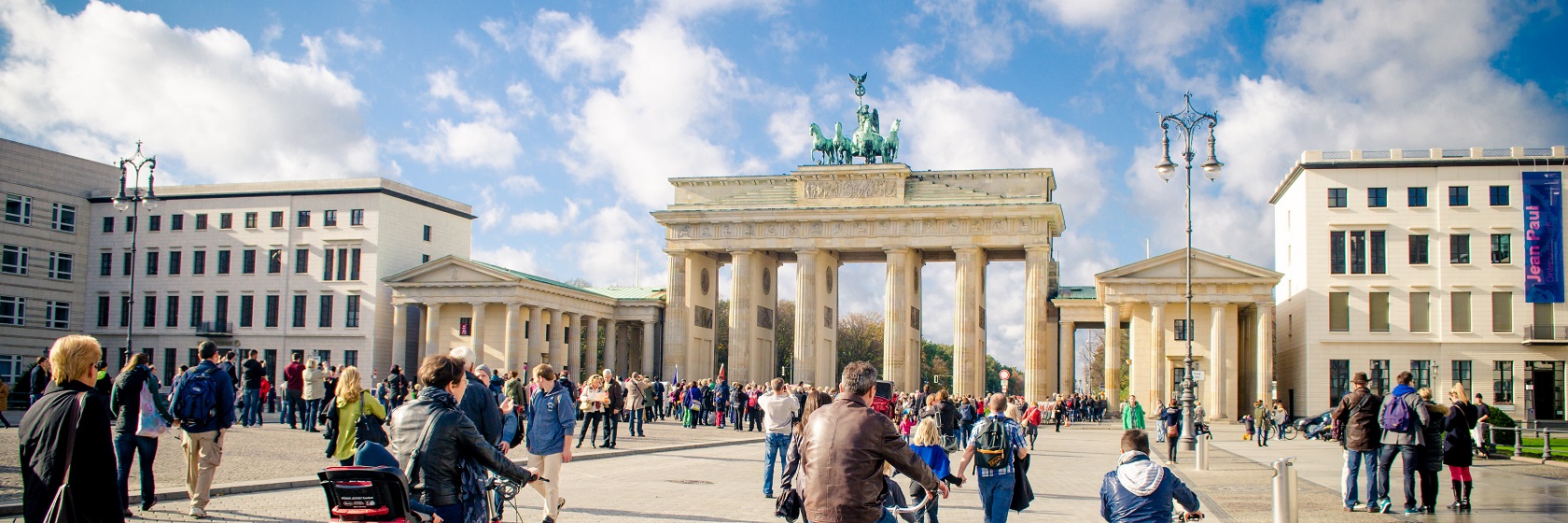 Brandenburger Tor i f�rmiddagsljus, med fullt av m�nniskor i r�relse.